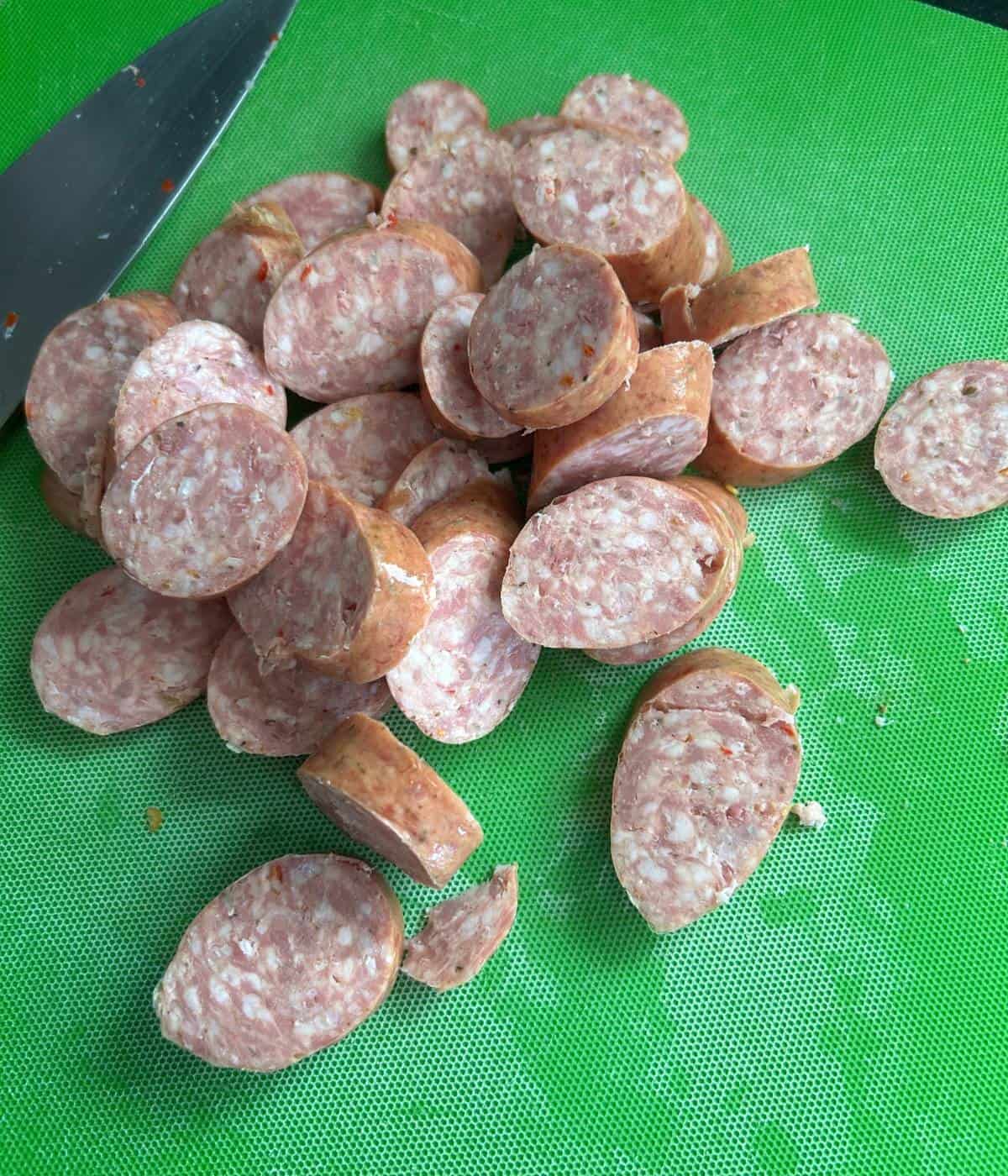 Sliced sausage on cutting board.