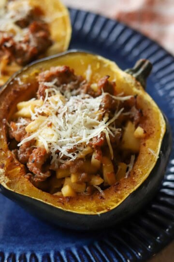 Apple and sausage stuffed acorn squash on plate.