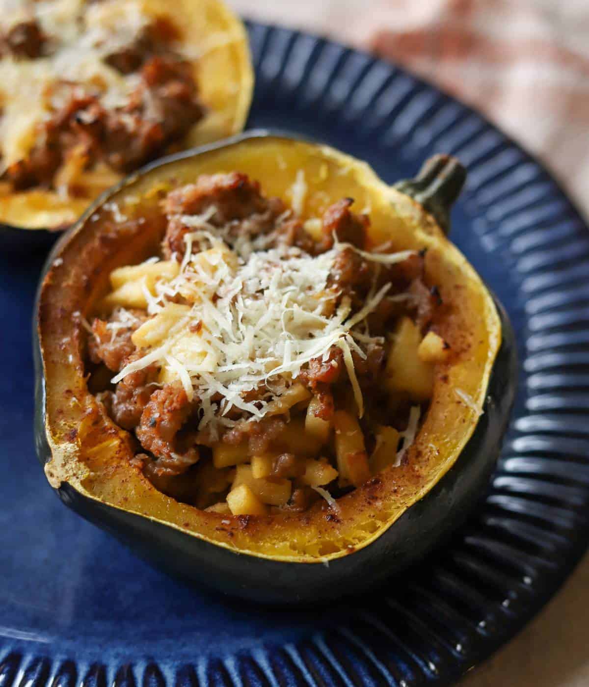 Apple and sausage stuffed acorn squash on plate. 