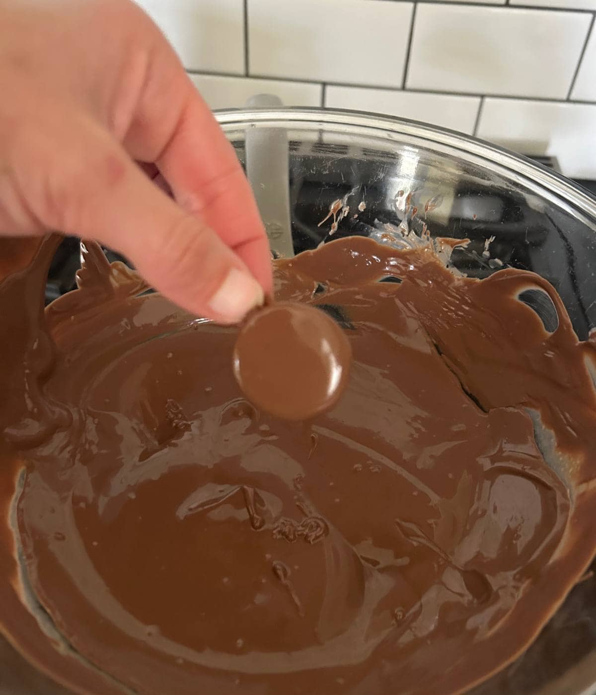 Dunking pecans in chocolate.