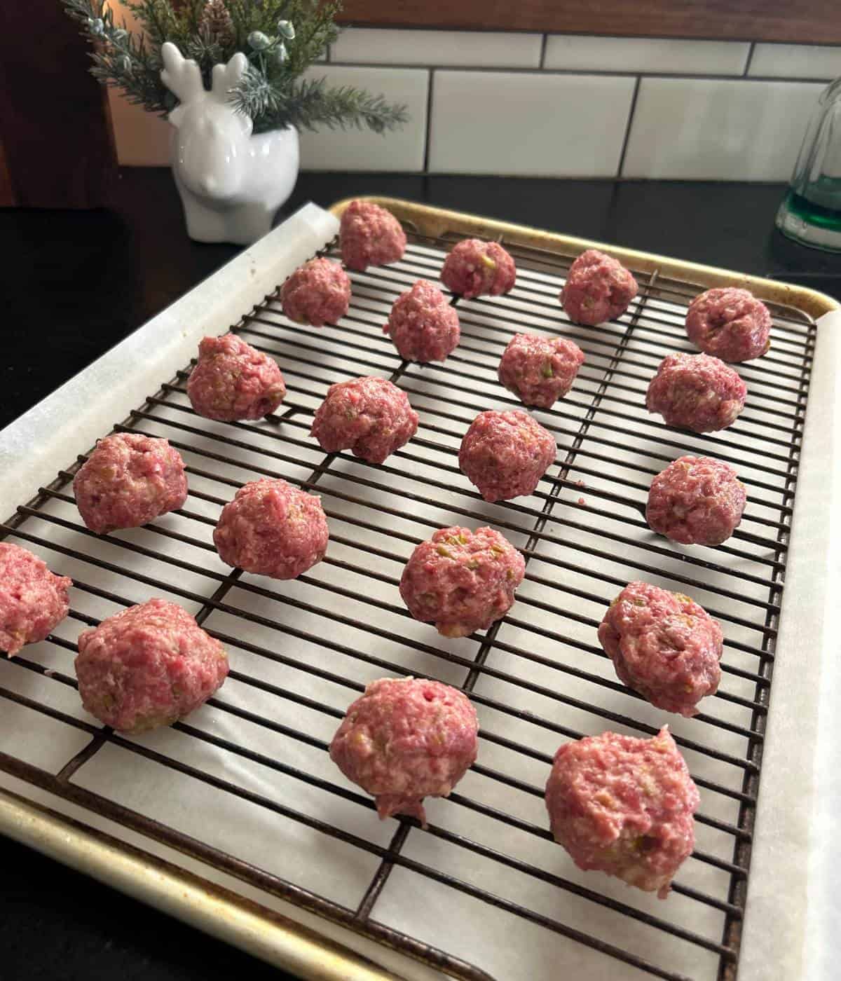 Raw meatballs on baking sheet.