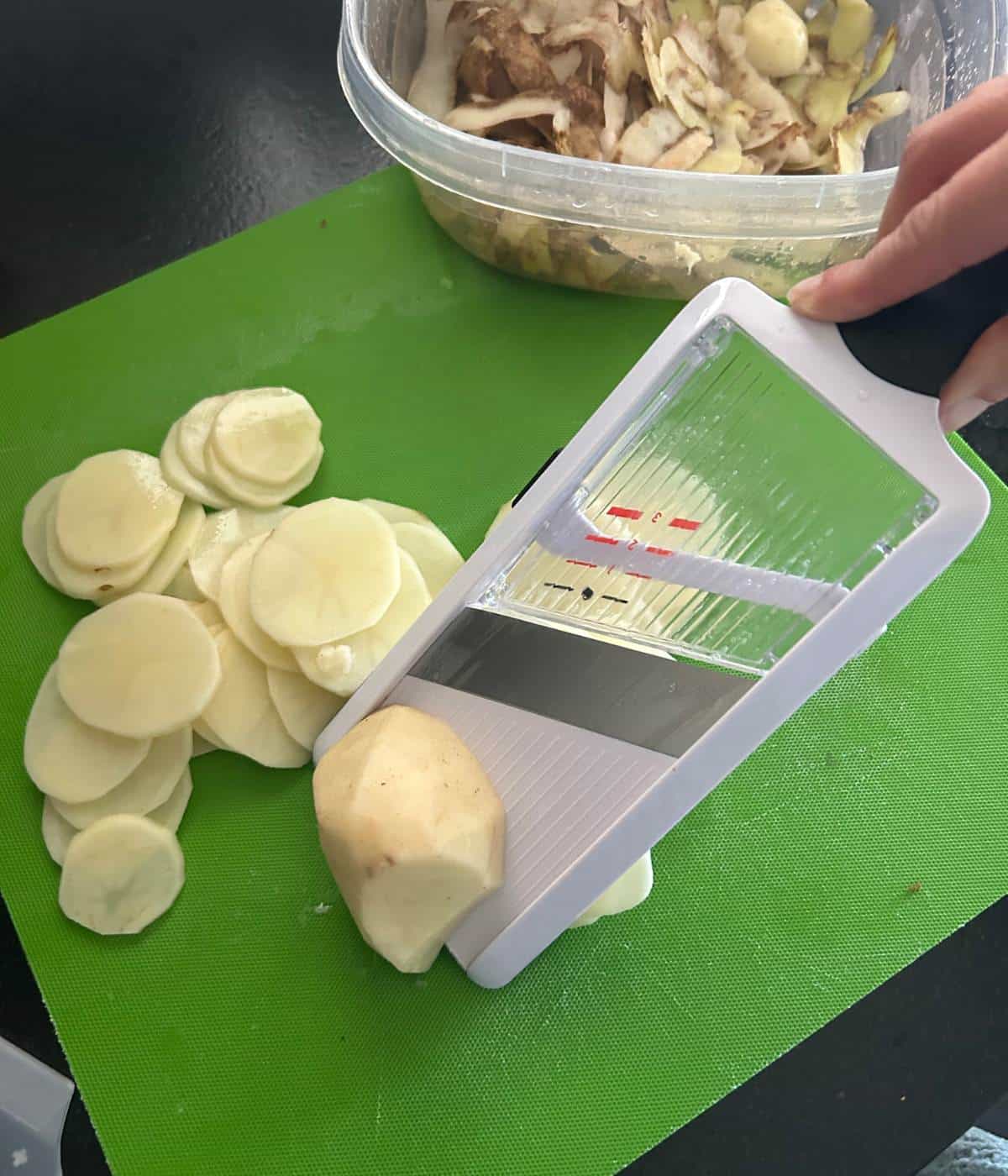 Sliced potatoes on mandoline.