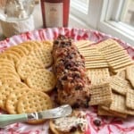 Cheese ball on platter with crackers.