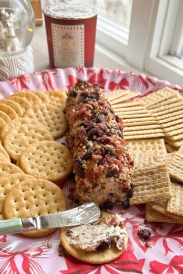 Cheese ball on platter with crackers.