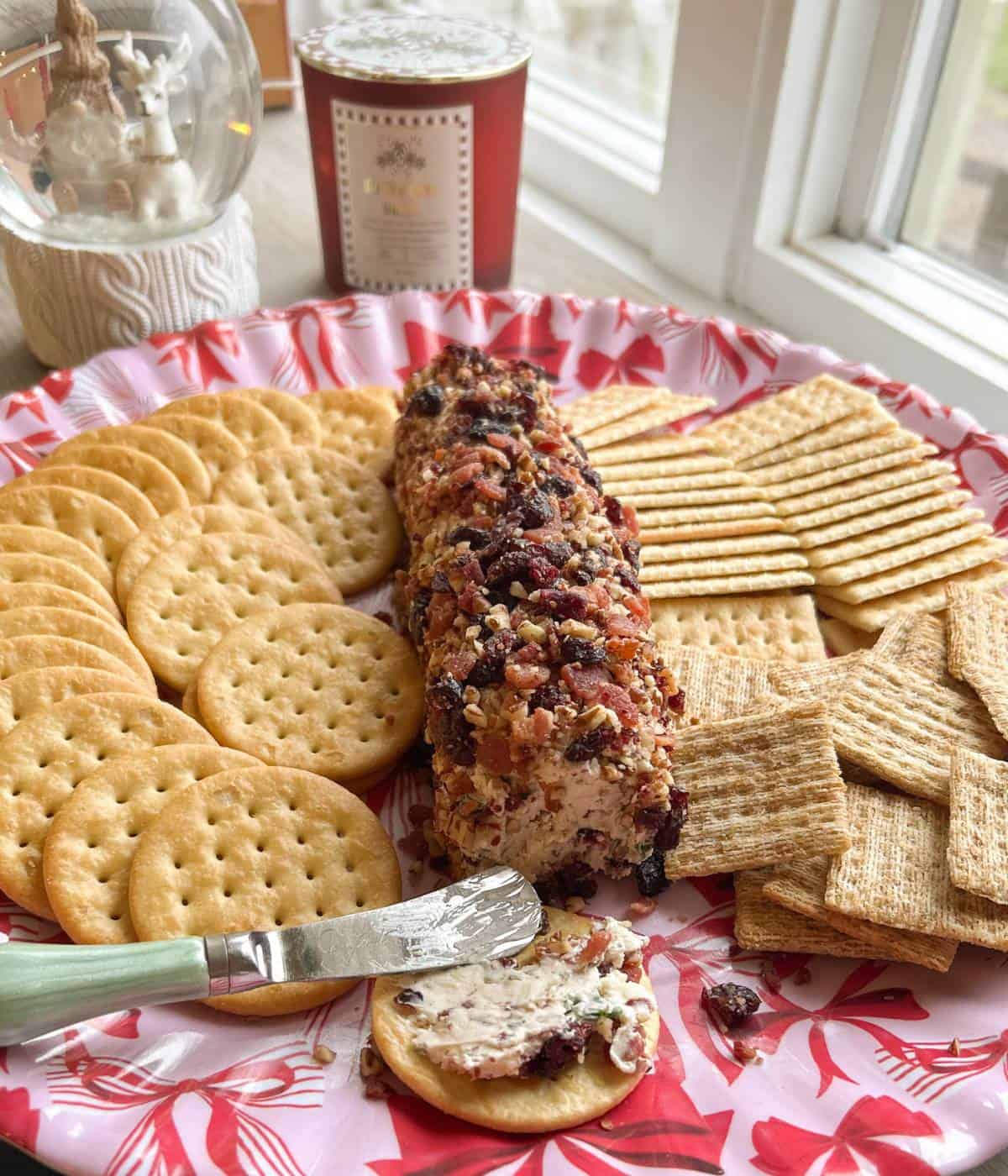 Cheese ball on platter with crackers.
