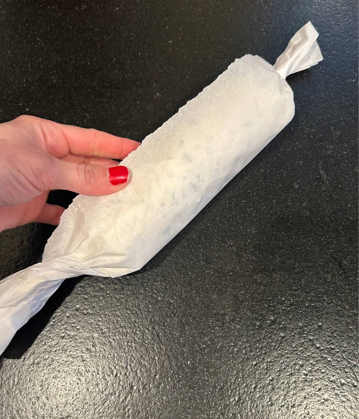 Cheese ball wrapped in parchment paper.