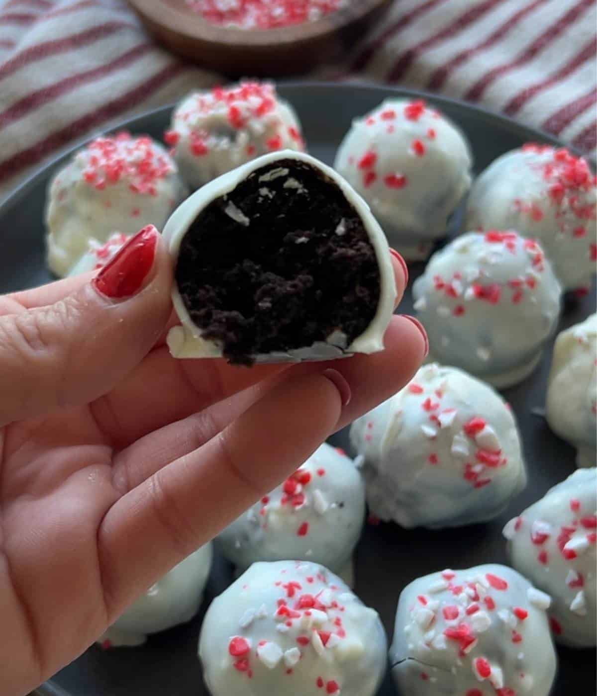 Hand holding truffle showing Oreo center.