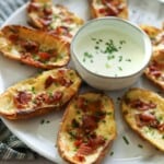 Crispy loaded potato skins on plate with homemade ranch.