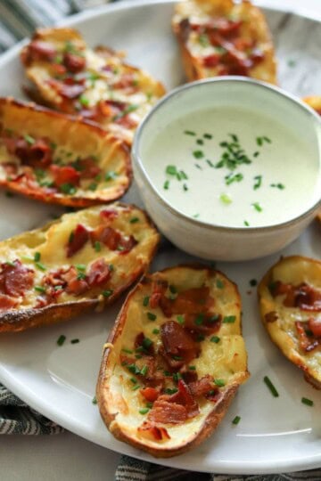 Crispy loaded potato skins on plate with homemade ranch.