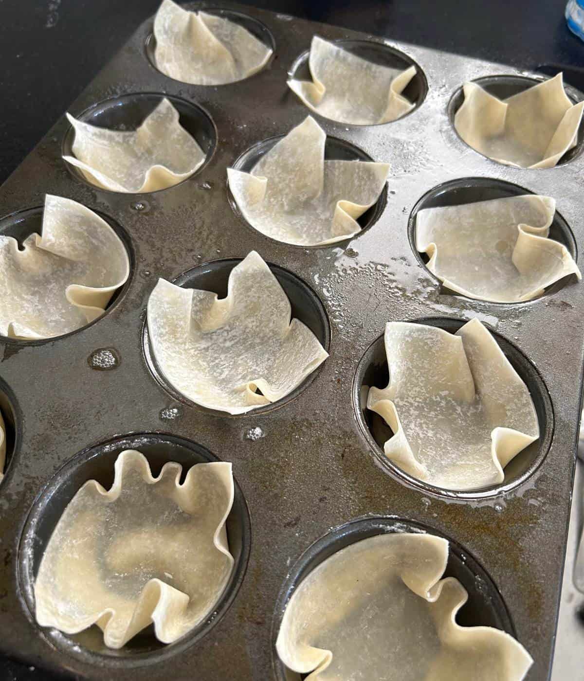 Wonton wrapped stuffed into muffin tin.