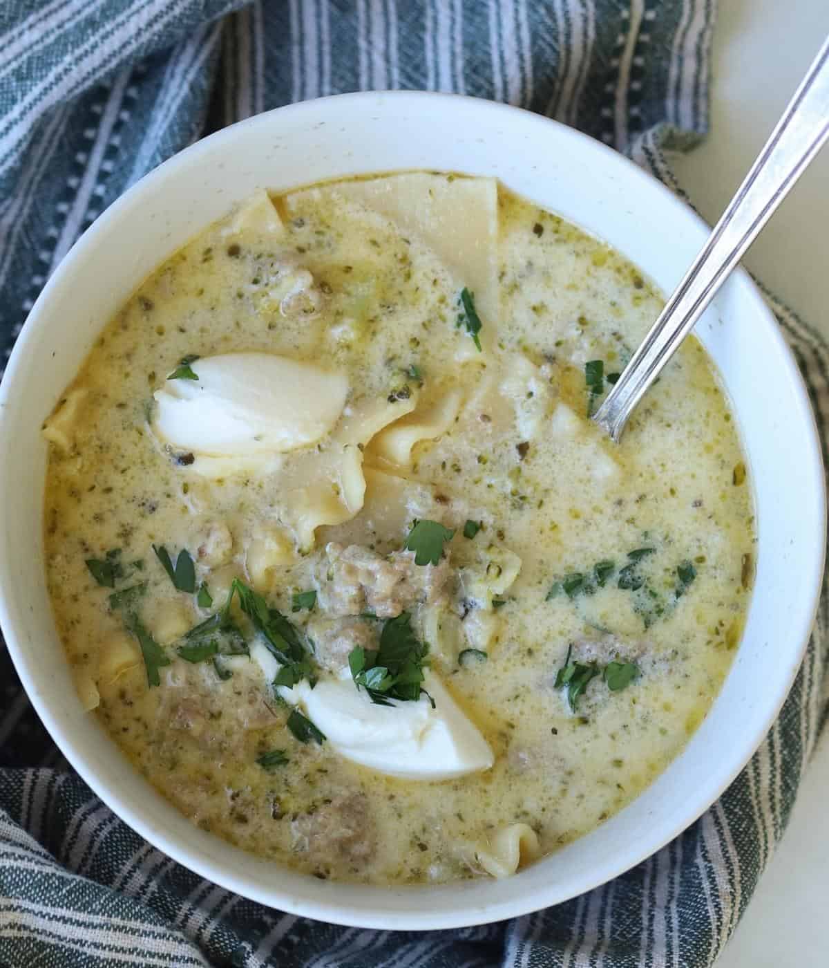 White lasagna soup with sausage in bowl.