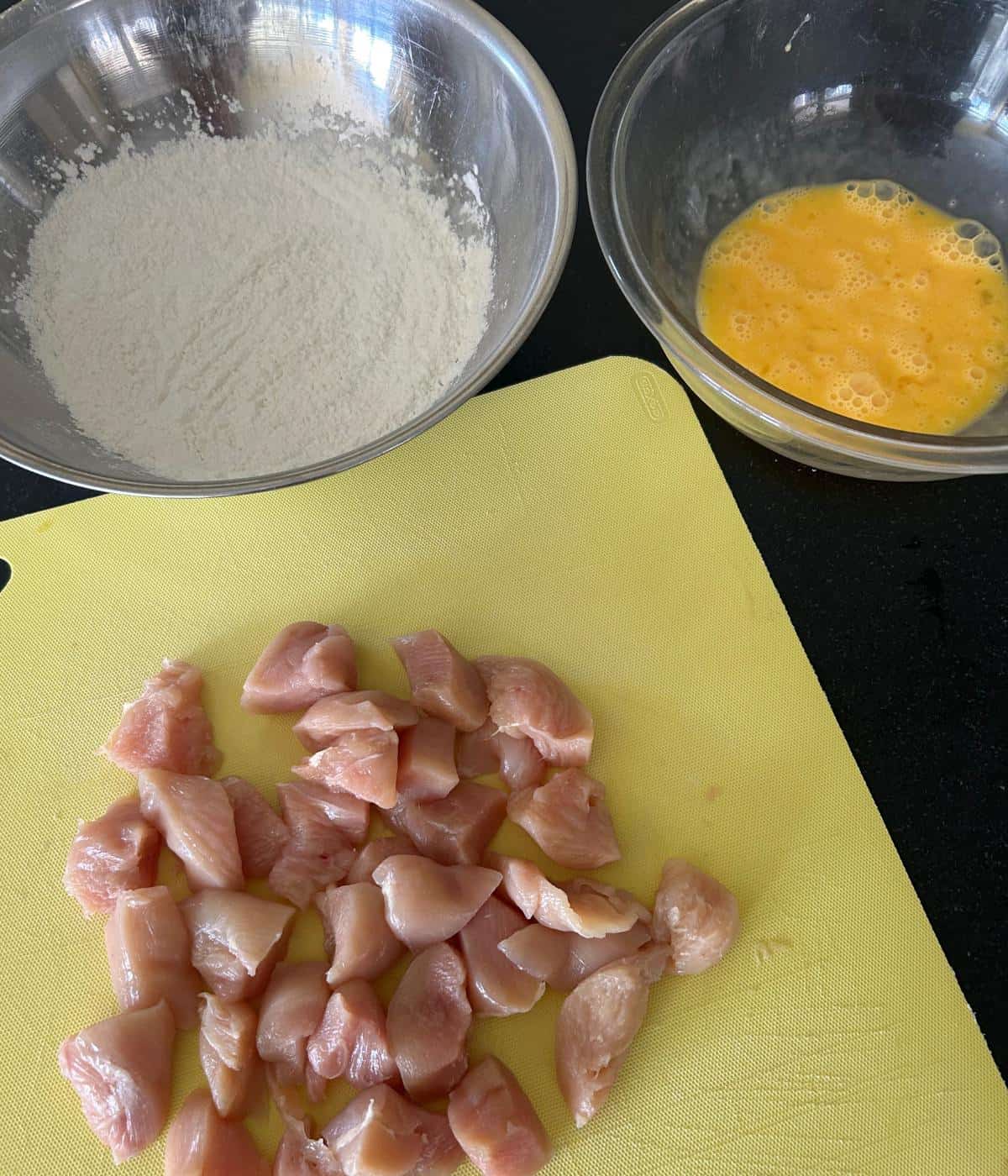 Chicken bites with bowl of flour and eggs.