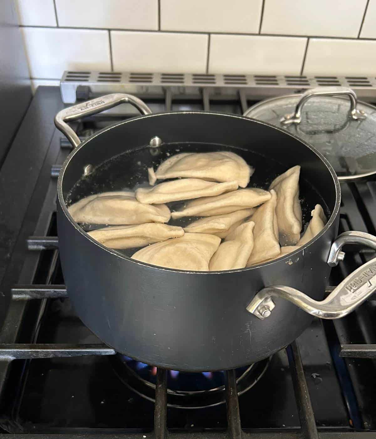 Boiled pierogies in pot.