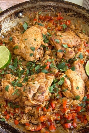 Chicken thighs with rice topped with cilantro and lime.