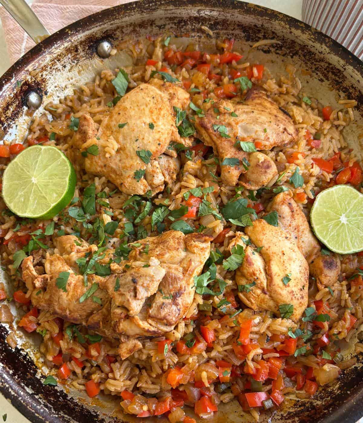 Chicken thighs with rice topped with cilantro and lime.