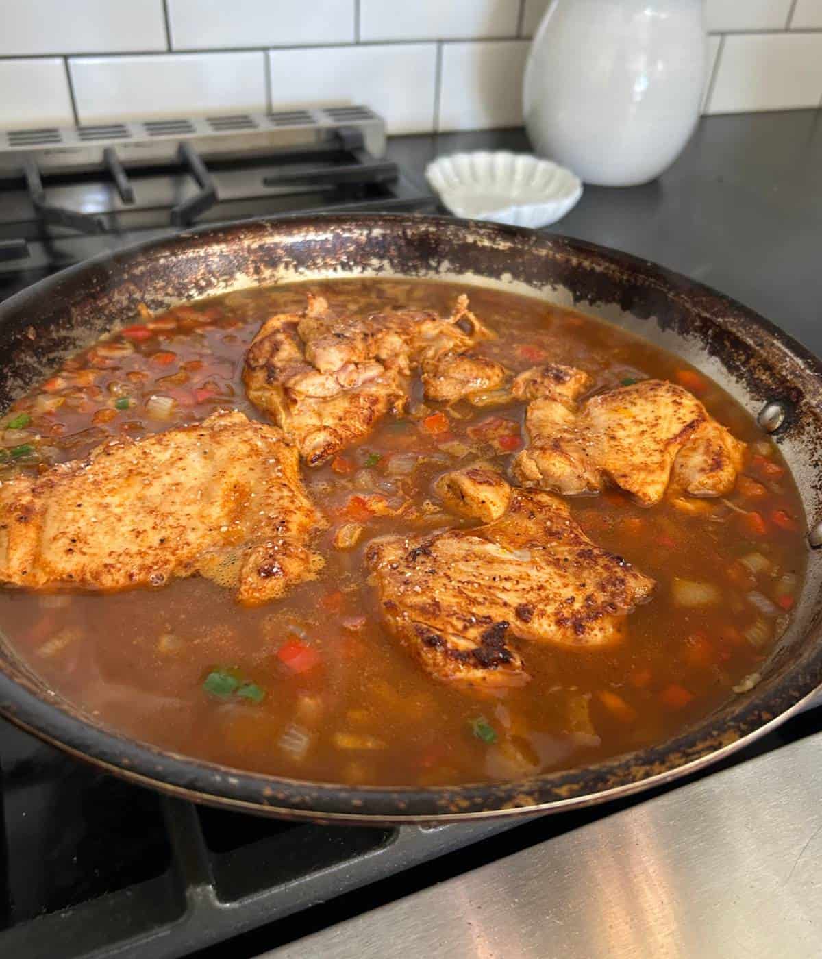 Chicken thighs and rice in stock.