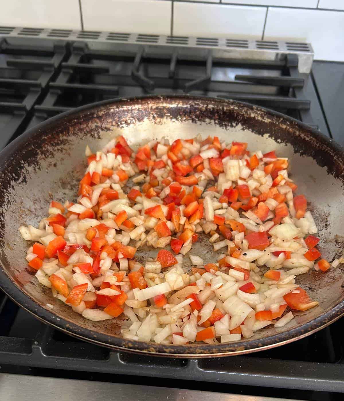 Peppers and onions in pan.