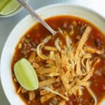 Taco soup recipe topped with tortilla strips.