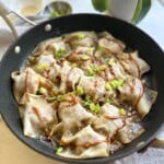 Pork dumplings topped with peanut sauce.