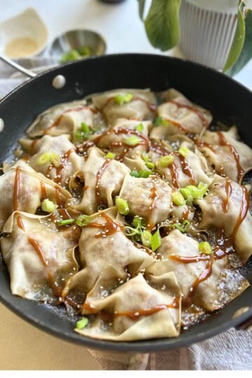 Pork dumplings topped with peanut sauce.