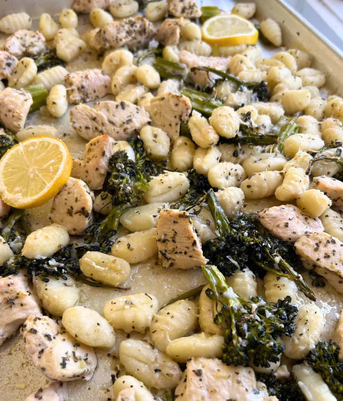 Gnocchi, broccolini and chicken on cookie sheet. 