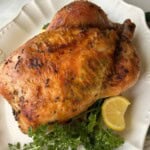 Roasted whole chicken on platter.