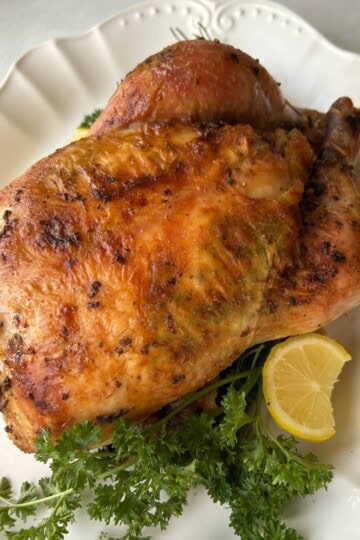 Roasted whole chicken on platter.