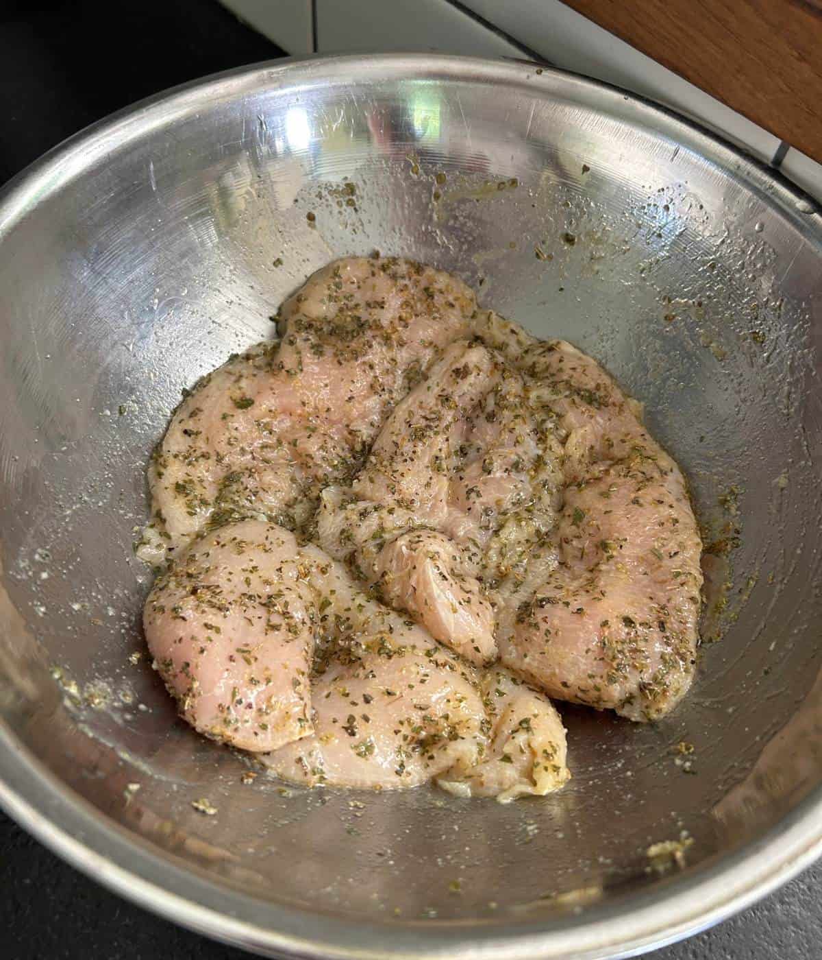 Grilled chicken marinating in bowl.
