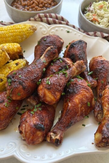 BBQ Chicken drumsticks with corn on platter.