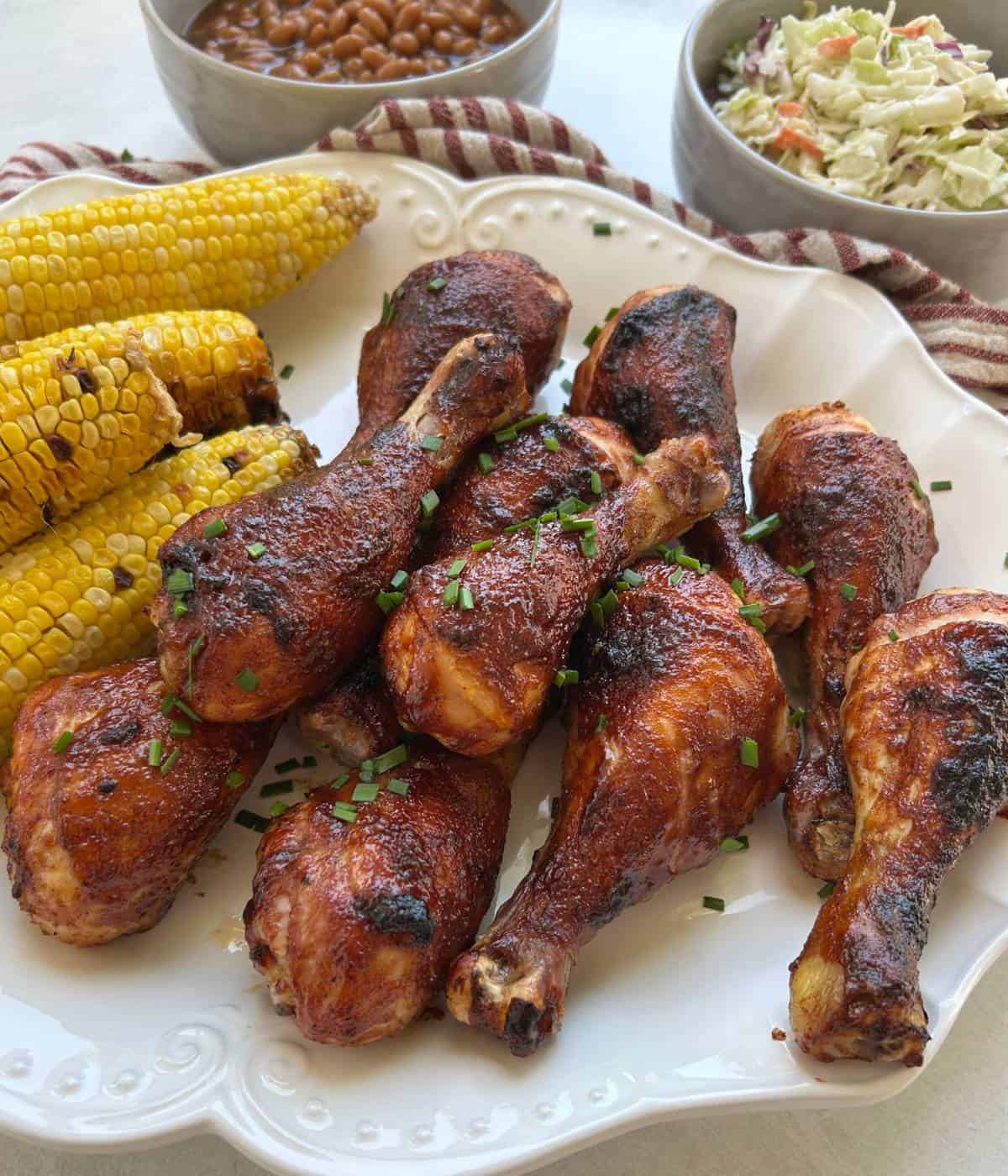 BBQ Chicken drumsticks with corn on platter.