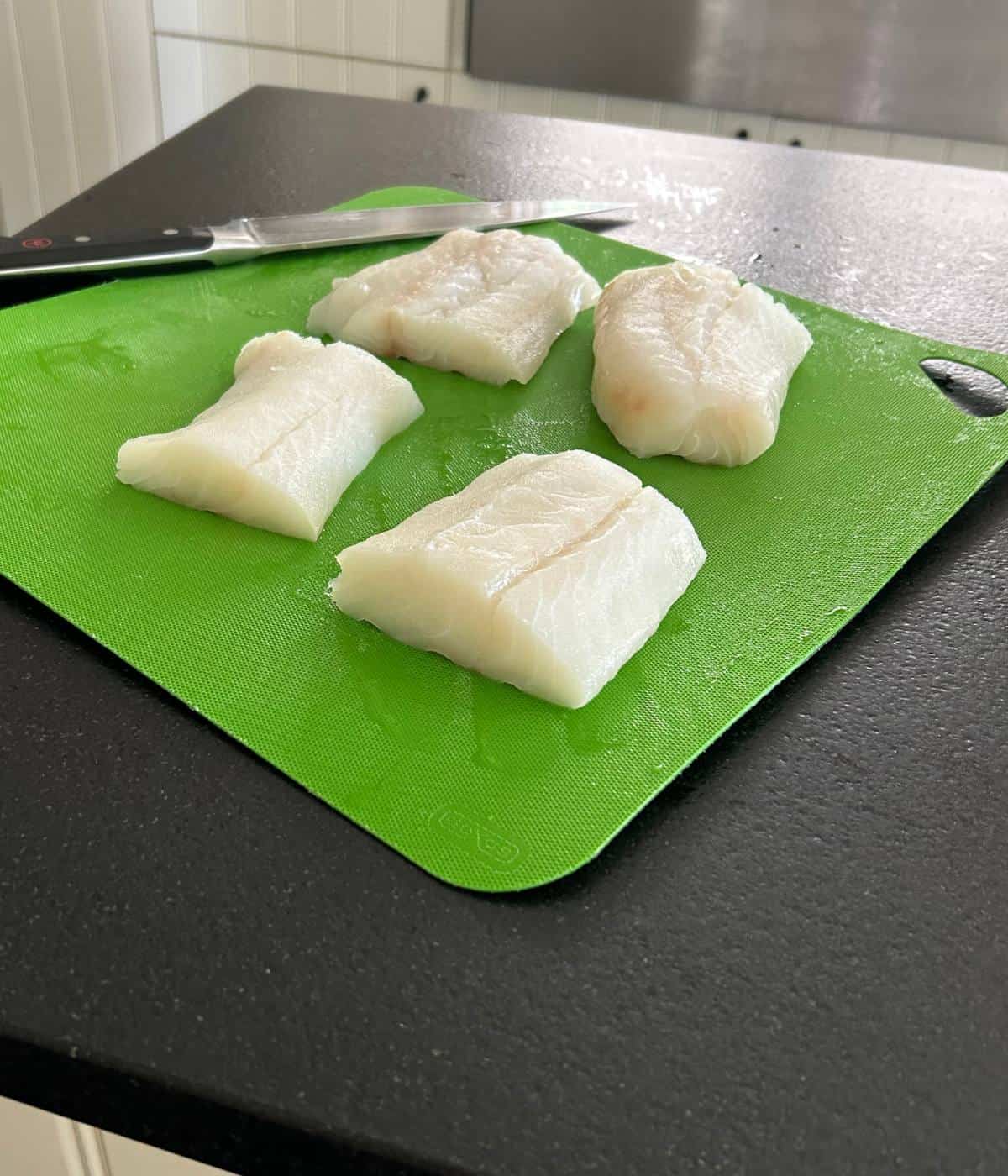 Cod filets on cutting board.