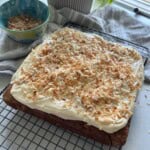 Banana bread with cream cheese frosting and toasted coconut topping.