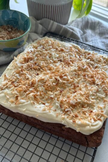Banana bread with cream cheese frosting and toasted coconut topping.
