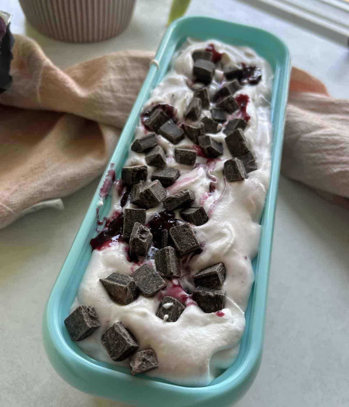 Cherry vanilla ice cream in tub.