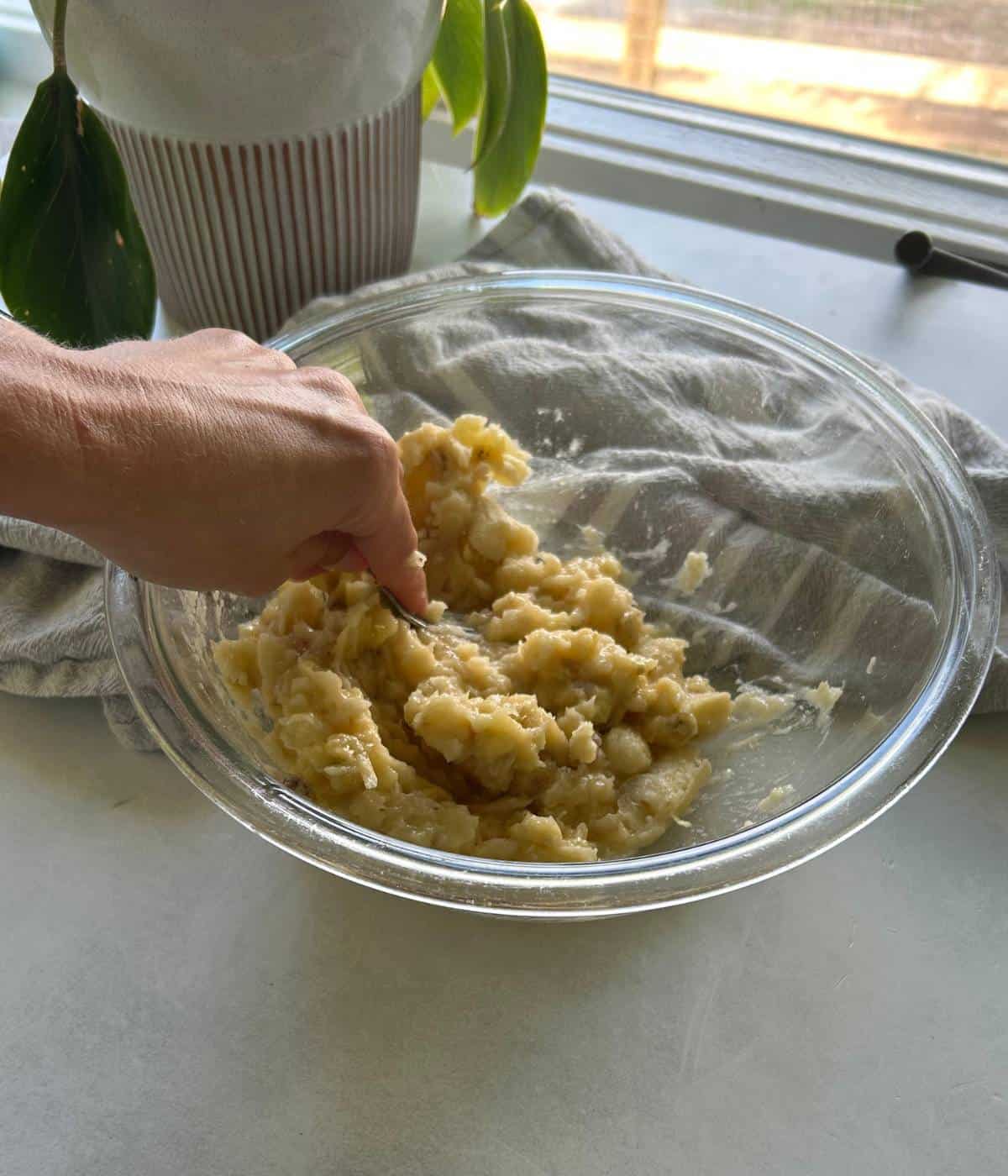 Mashing bananas with fork.