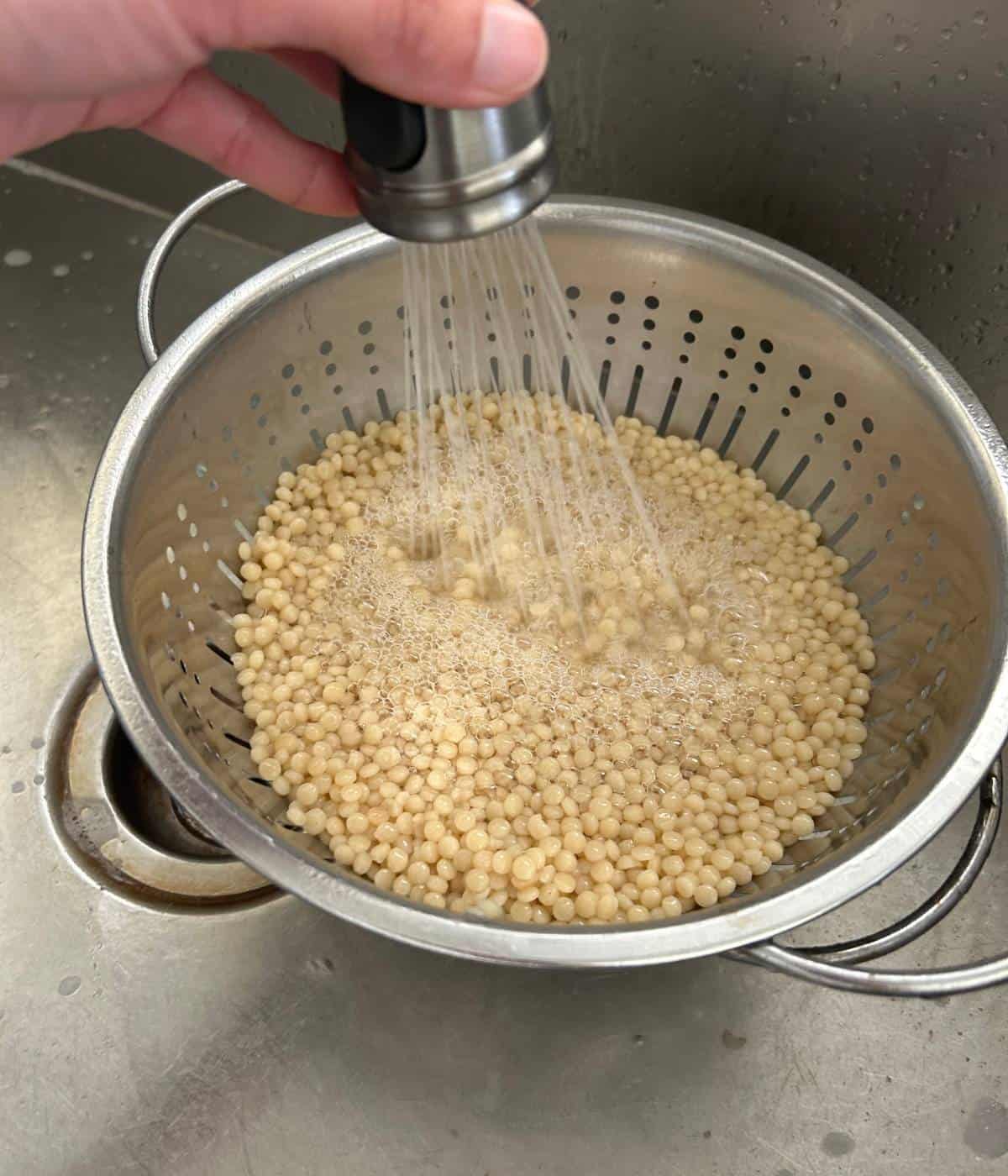 Rinsing couscous in strainer.