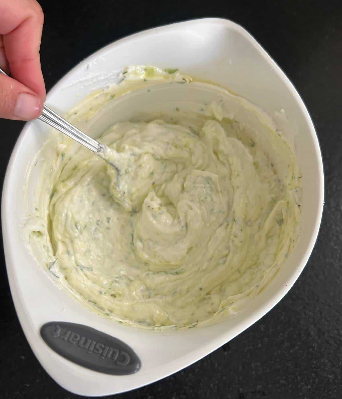 Stirring up tzatziki sauce.