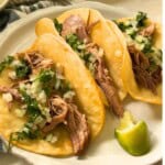 Pork Carnitas tacos with cilantro and onion.