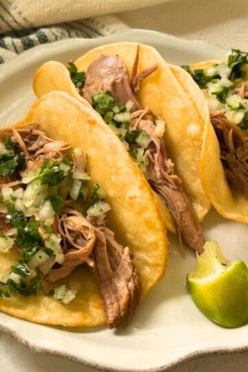 Pork Carnitas tacos with cilantro and onion.