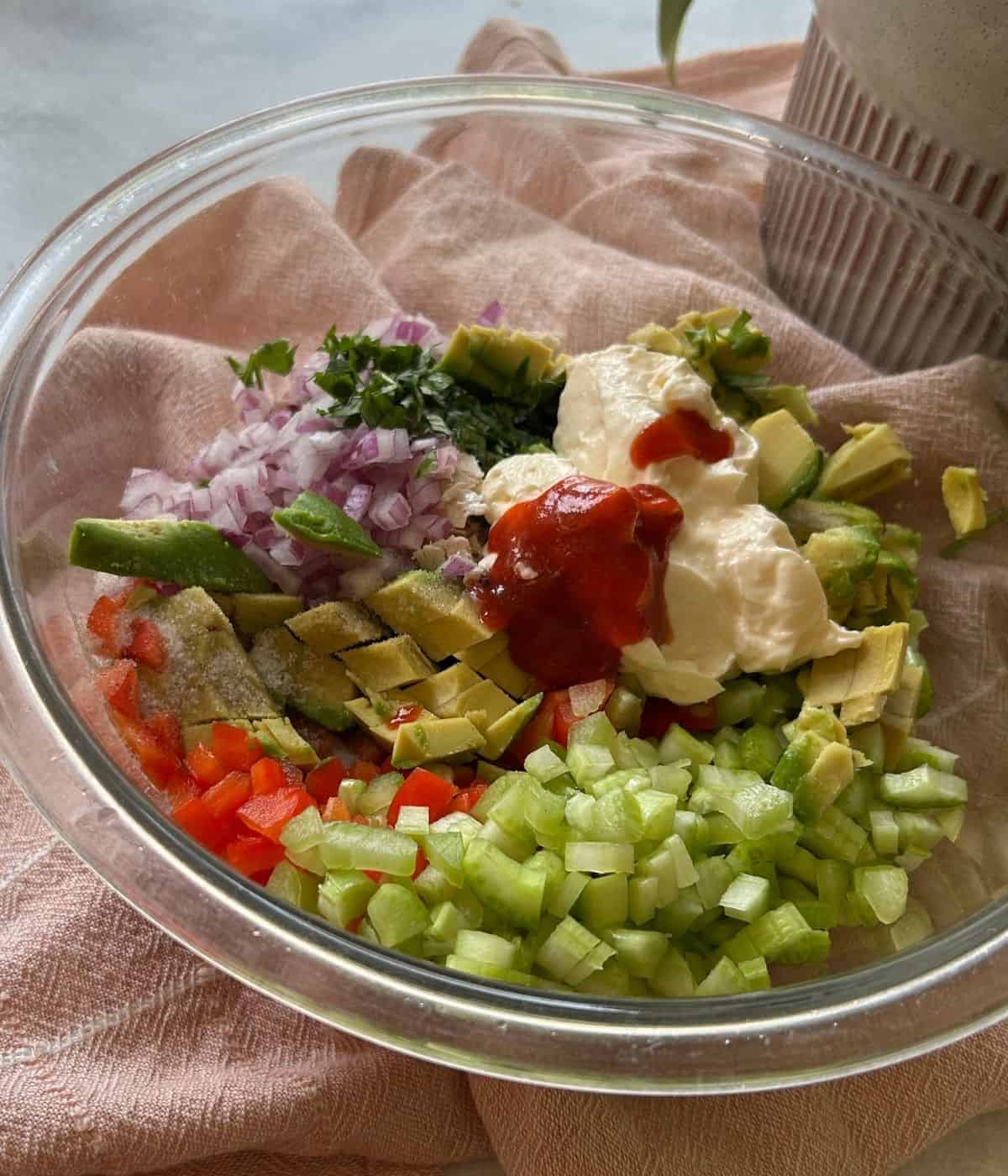 Ingredients for sriracha mayo chicken salad in bowl.