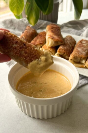 Cheeseburger egg roll dipped in sauce.