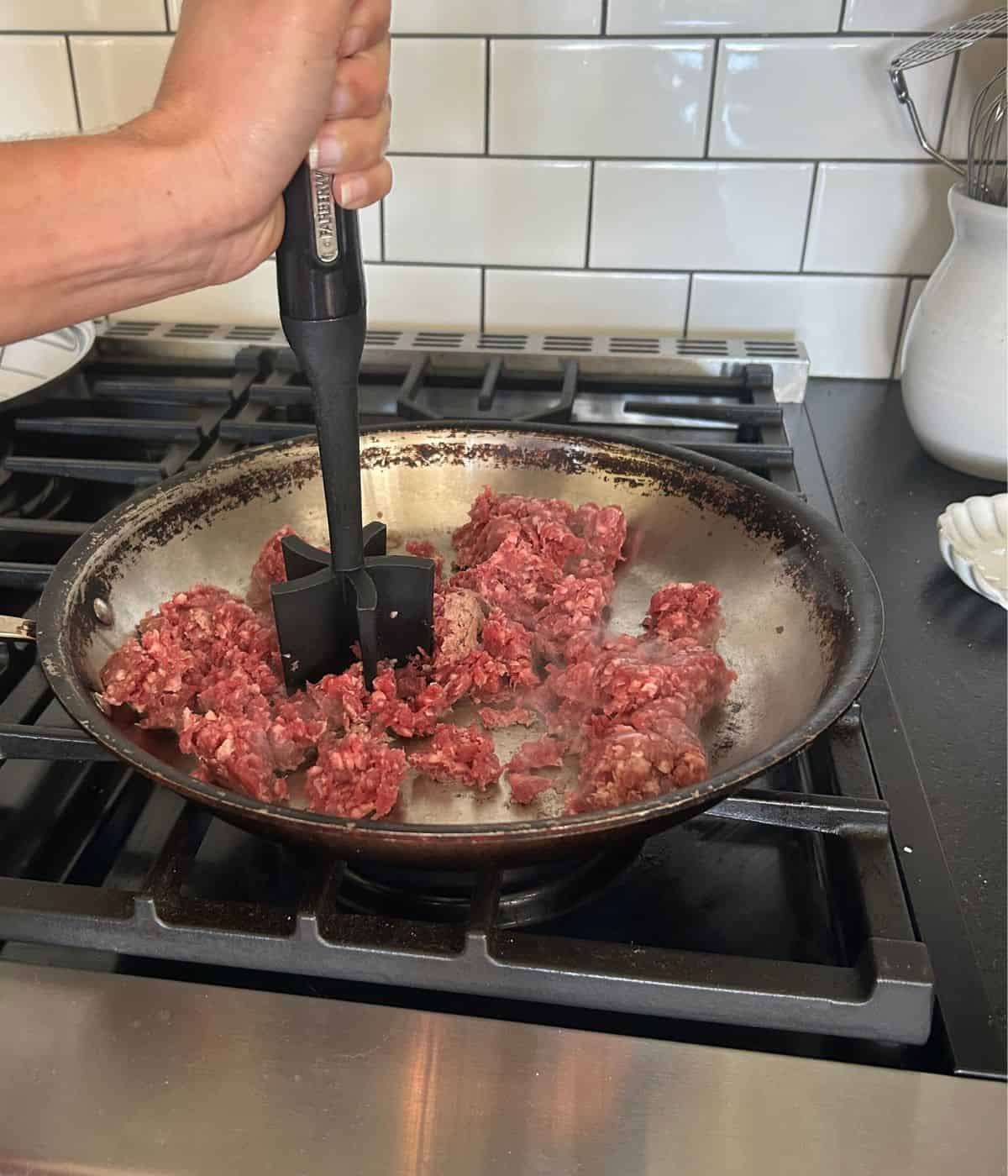 Cooking ground beef in pan.