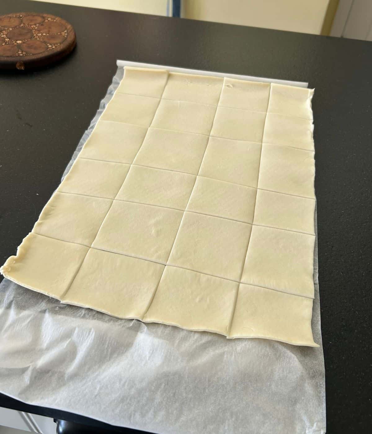 Cutting puff pastry into squares.